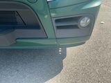 a close up of a green car with a black hood