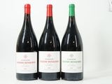 trois bouteilles de vin rouge sont alignées sur une surface blanche
