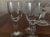 three wine glasses sitting on a table with a white wall in the background