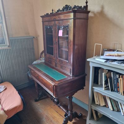 un piano dans une pièce où se trouvent un lit et une bibliothèque