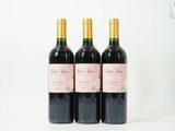 trois bouteilles de vin posées sur une table blanche