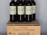 quatre bouteilles de vin se trouvent dans une caisse en bois posée sur une table