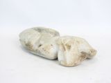 two white rocks sitting on a white surface