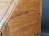 an old wooden writing desk with a drawer on top of it