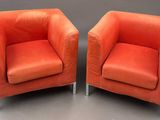 pair of orange leather chairs with chrome legs