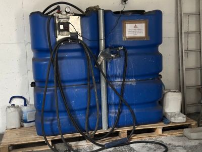 deux fûts bleus posés sur une palette dans un garage