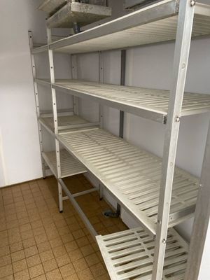 une étagère blanche comportant des tablettes, dans une pièce