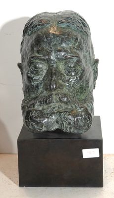 sculpture représentant une tête d'homme posée sur un socle en bois