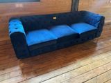 a blue couch sitting on a wooden floor in a room