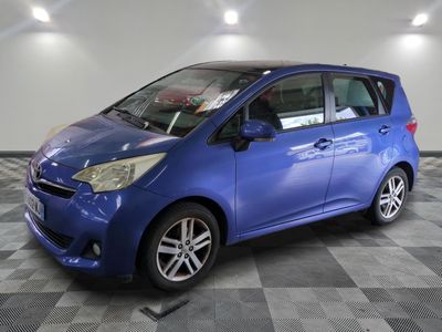 une voiture bleue garée dans un garage au sol en damier