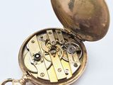a gold pocket watch with a chain attached to it