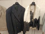 two jackets hanging on a clothes rack in a room