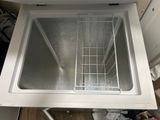 a small freezer that is open in the kitchen