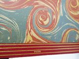 a close up of a red and blue book with swirly designs on it