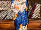 une statue de femme tenant un enfant sur une table