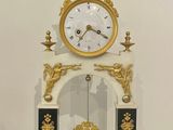 une horloge blanche et dorée posée sur une table en bois