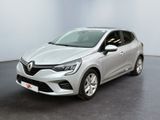 Une voiture argentée est garée dans une pièce au sol noir.