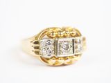 gros plan d'une bague en or et diamants sur une surface blanche