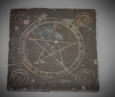 a stone with a pentagram on it on a wall