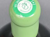 a close up of a bottle of wine with a green cap