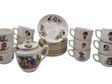 many cups and saucers with pictures of children on them