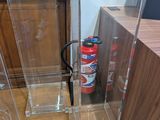 a fire extinguisor and a fire hydrant in the corner of a room