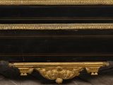 an antique black and gold painted chest of drawers with gold trimming