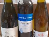 three bottles of wine sit in a cardboard box on a table