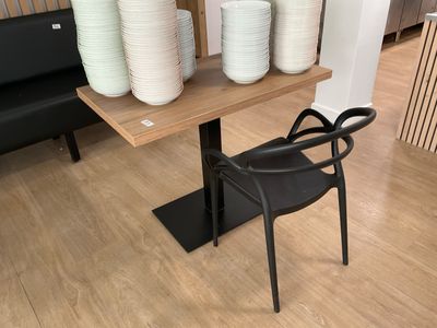 a black chair sitting in front of a table with plates on it