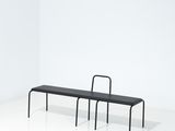 un banc noir et une chaise noire dans une pièce blanche