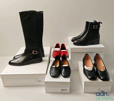 Plusieurs paires de chaussures pour femmes, noires et rouges, sont exposées.