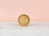 an image of a gold coin sitting on top of a marble slab