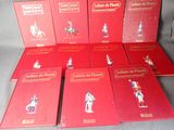 six livres rouges ornés de figurines de soldats, posés sur une table