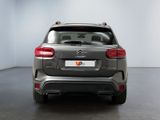 the rear end of a grey citrole parked in a white room