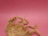 a long blonde hair on a pink surface