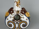 a white vase with a blue and gold decoration on it