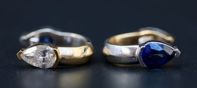 deux bagues en or et en argent, ornées de saphirs bleus, sur un fond noir