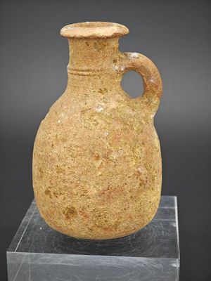 un vase en pierre muni d'une anse, posé sur un socle