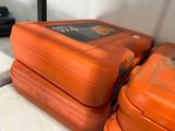 trois valises orange posées les unes à côté des autres sur une étagère