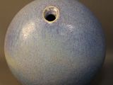 un vase bleu troué posé sur une table