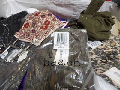 a pile of clothes and other items on a bed