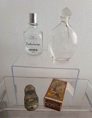 une vitrine en verre contenant un flacon de parfum et un coffret de parfum