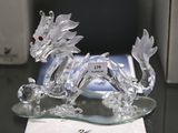 crystal figurine of a dragon on a glass plate on a table