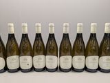 six bottles of white wine are lined up on a table