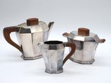 three pieces of silver and wood coffee set on a white surface