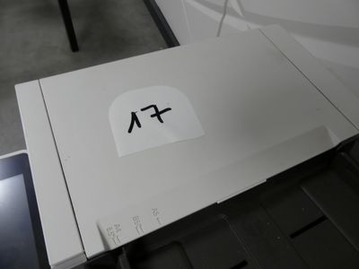 une boîte blanche sur laquelle est collé un autocollant, posée sur une table