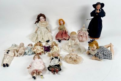 a lot of dolls that are sitting on a white surface