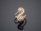 a gold ring with two diamonds on a black surface