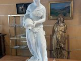 une statue de femme tenant un bébé sur une table