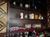 de nombreuses bouteilles et verres sur les étagères du bar
